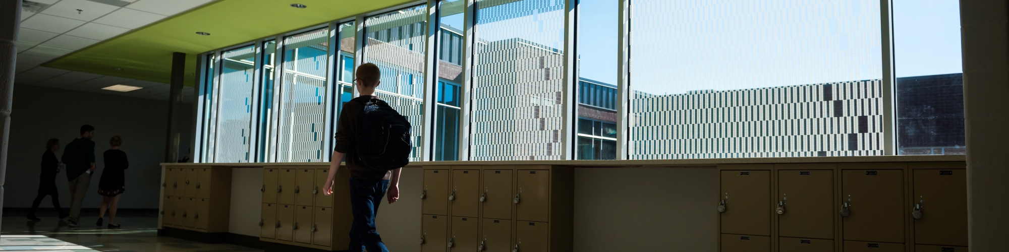 Boy walking down a school hallway