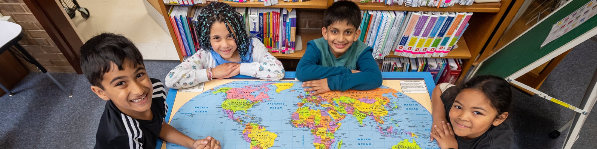 students looking at world map