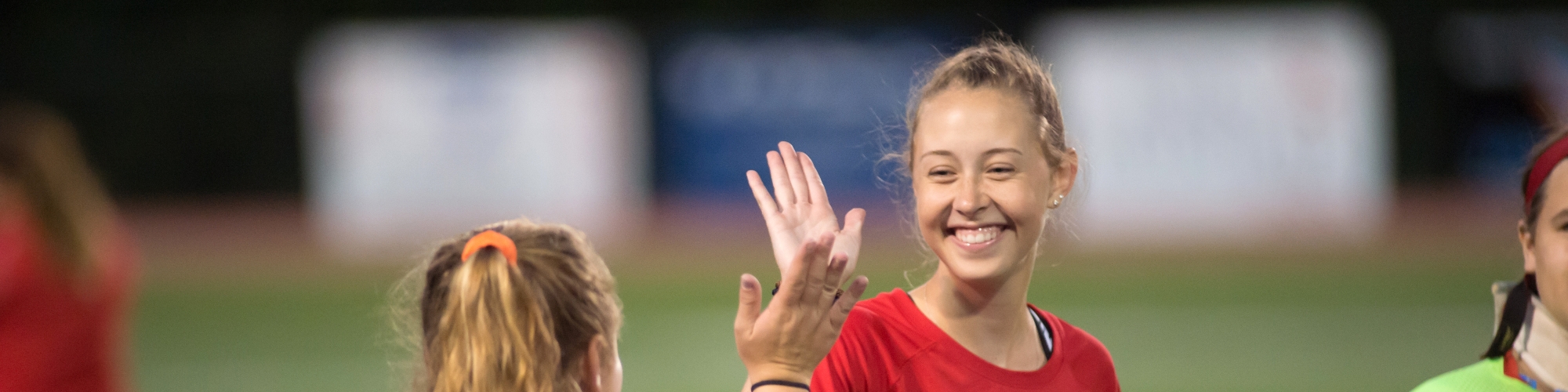 Photo of two female athletes giving each other a high five