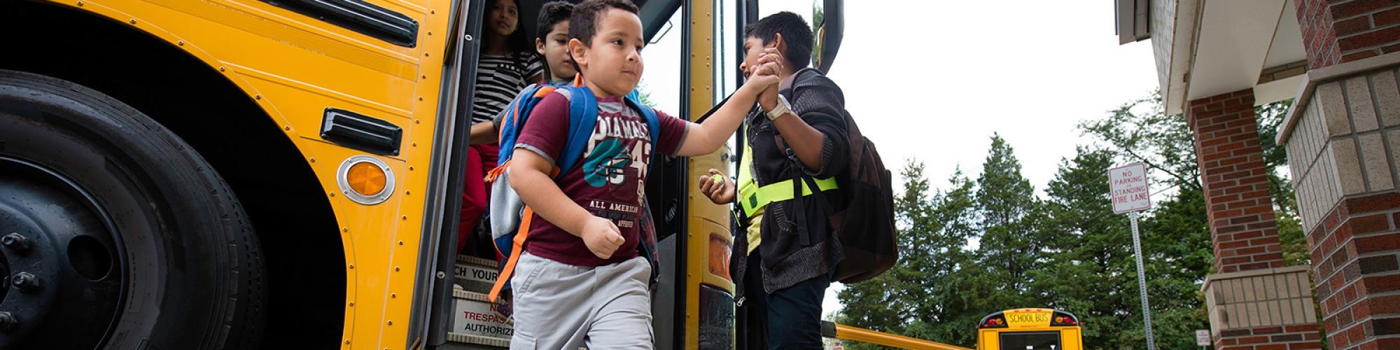 a photo of a young student getting off the bus.