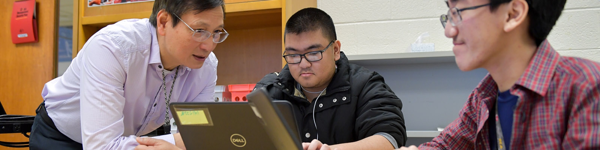 a high school teacher helping students