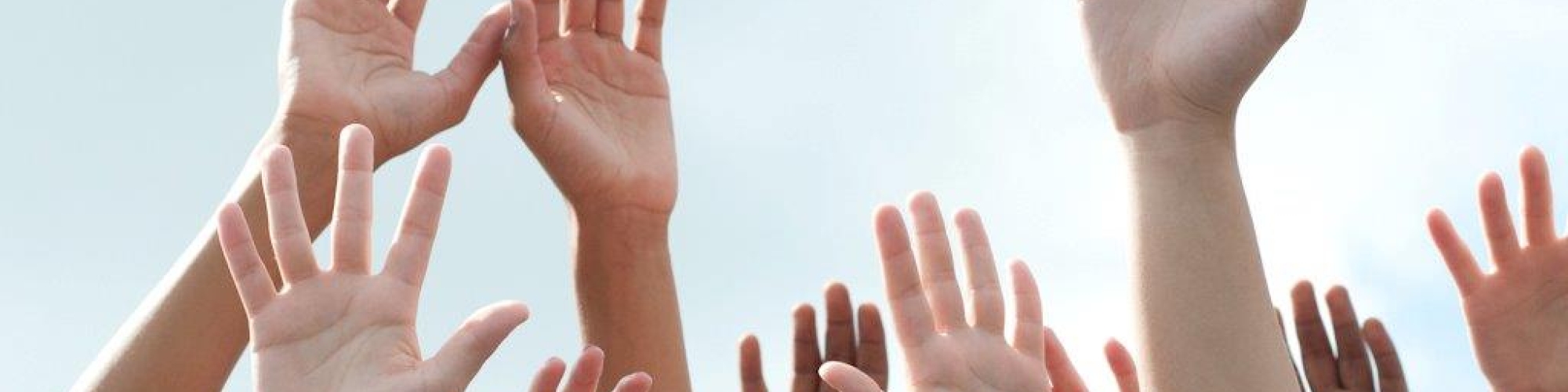 student hands reaching upward